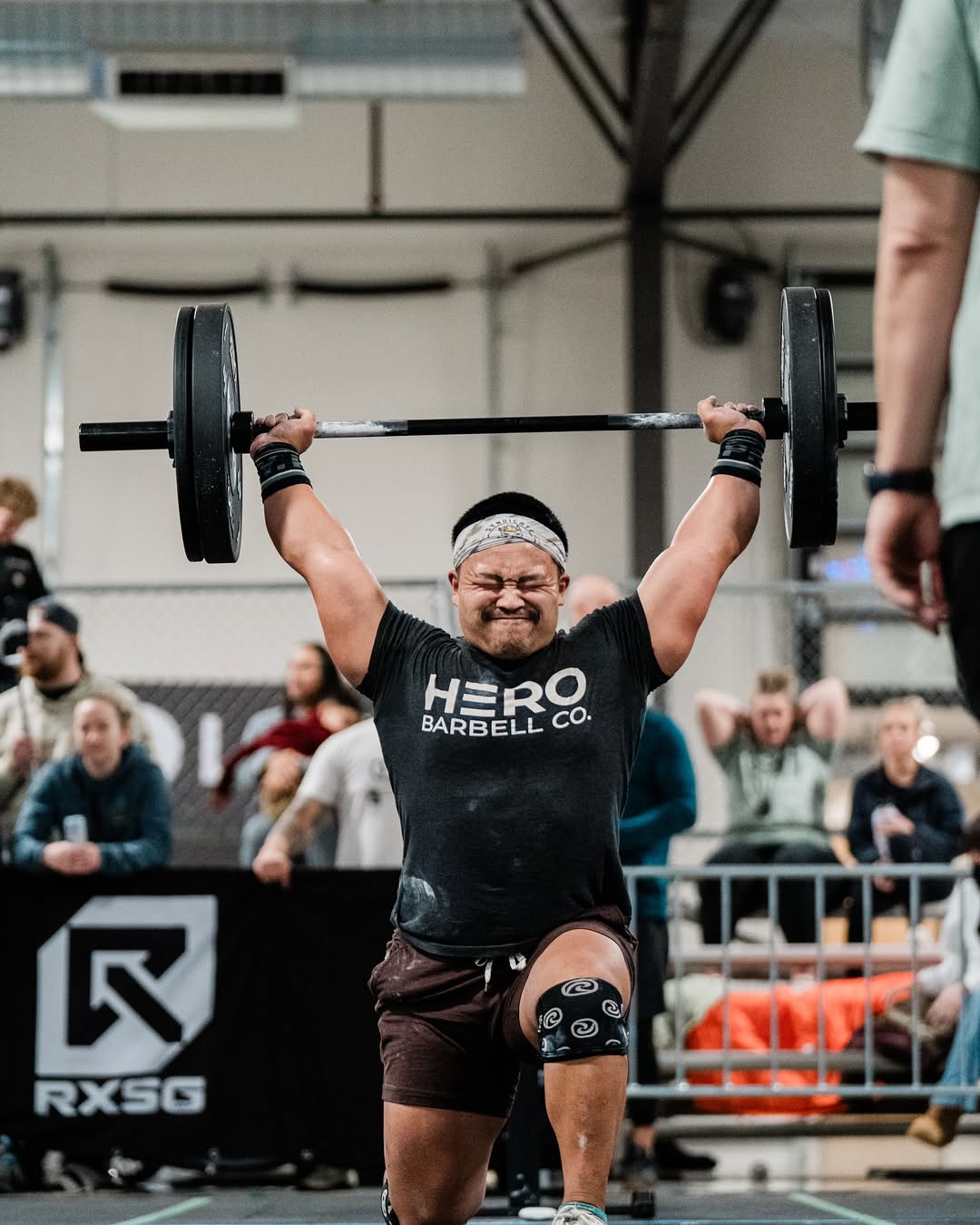 Athlete performing overhead lunges with weights